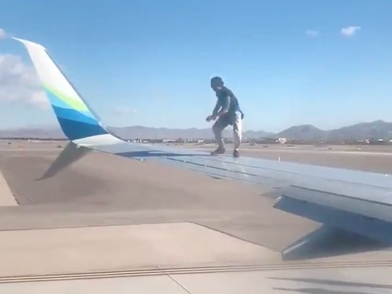 Un hombre se subió al ala de un avión cuando estaba a punto de despegar